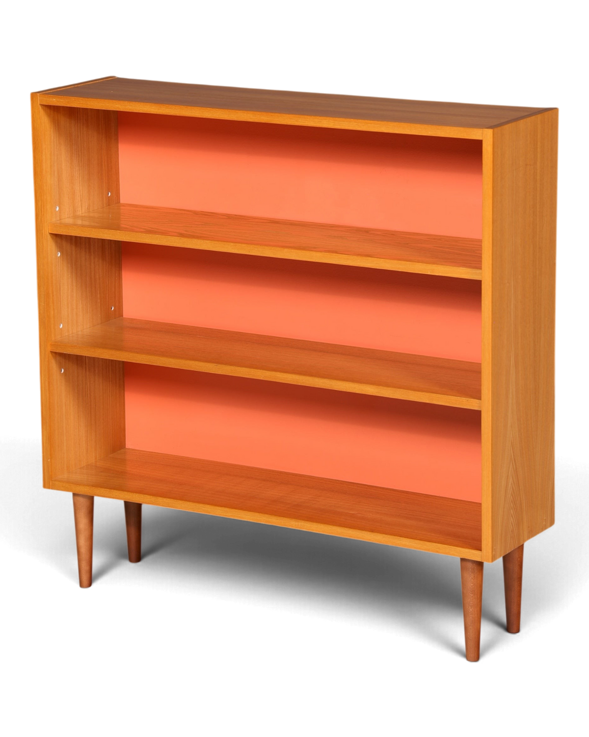 Hauptstadt Möblerei Mid-Century Bücherregal aus Holz mit leuchtend orangefarbener Rückwand und konischen Beinen