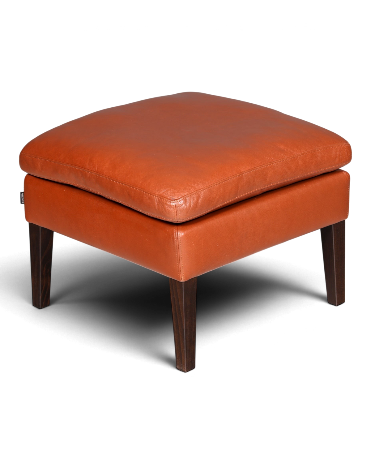 Hauptstadt Möblerei Hocker aus cognacfarbenem Leder mit dunklen Holzbeinen im modernen Design